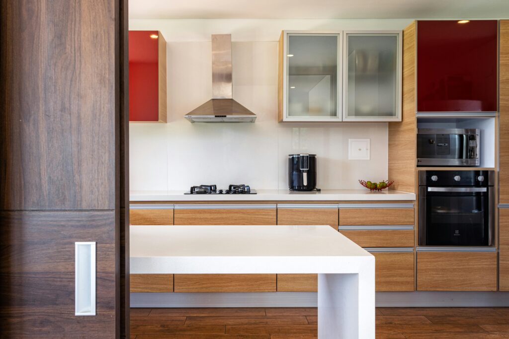 Stylish kitchen featuring wooden cabinets, glossy surfaces, and modern appliances.
